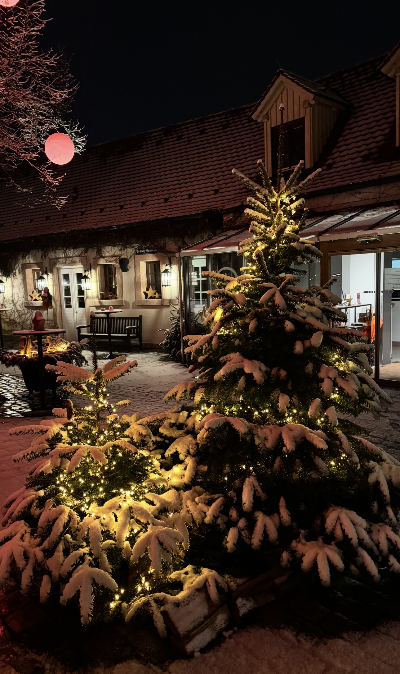 Moderne Holzfassade des Schindlerhof-Gebäudes mit orangenem Akzent und umgebendem Grün