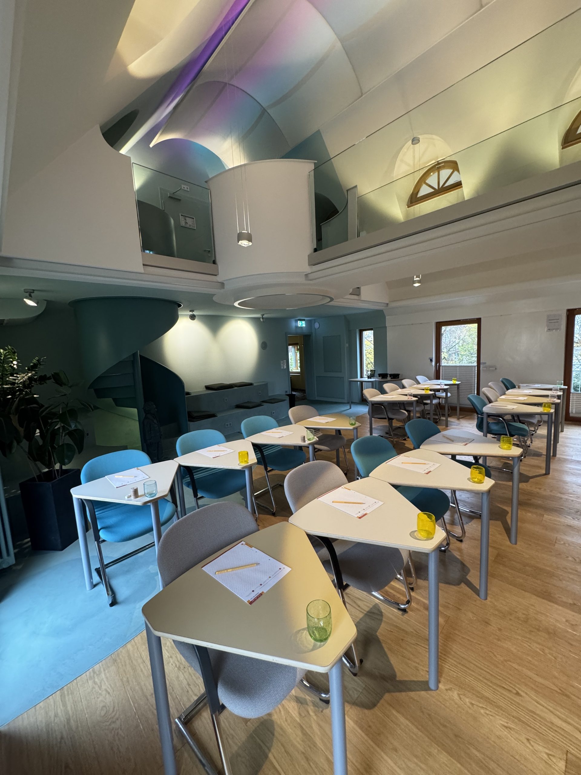 Moderne Holzfassade des Schindlerhof-Gebäudes mit orangenem Akzent und umgebendem Grün