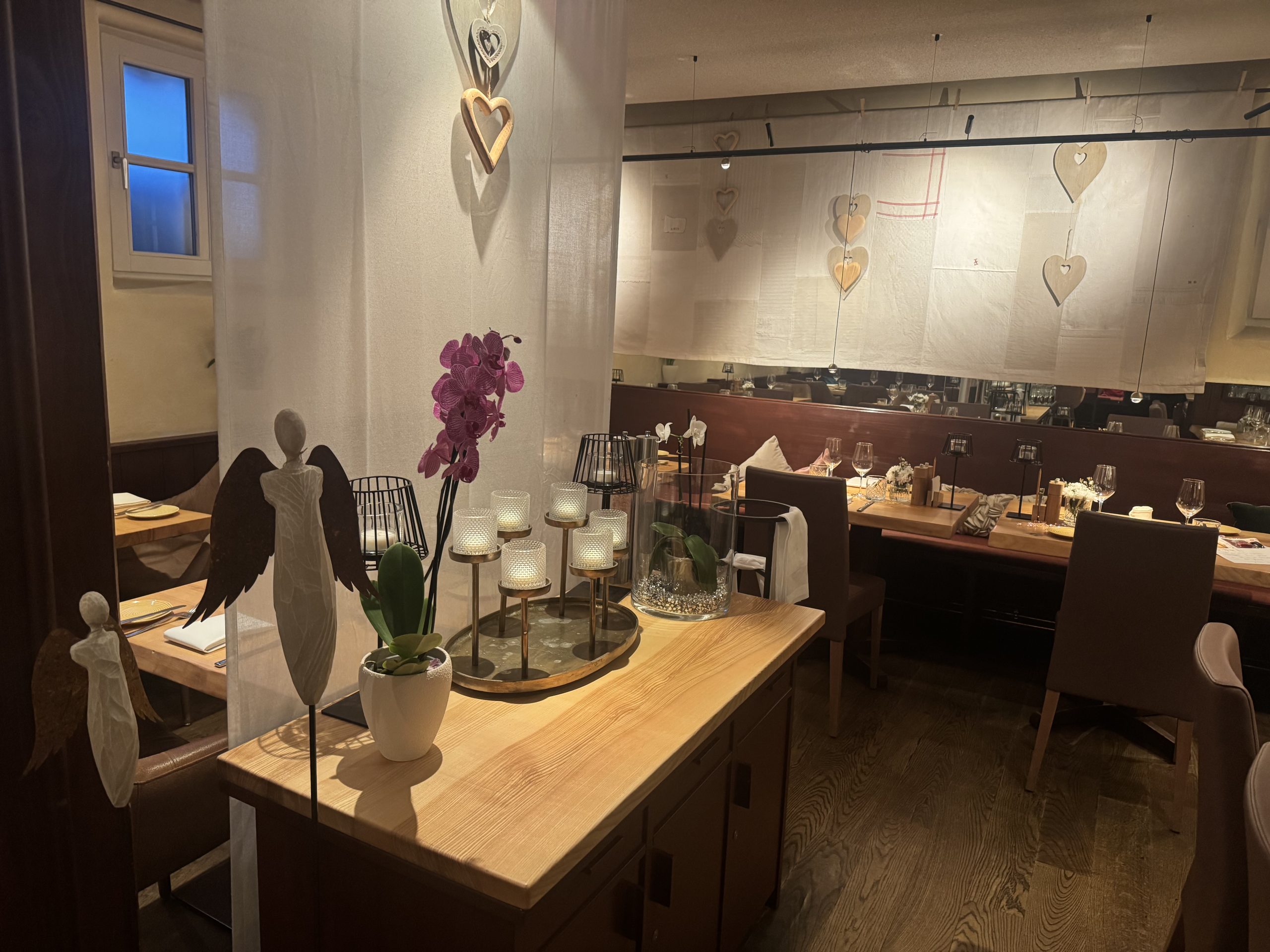 Moderne Holzfassade des Schindlerhof-Gebäudes mit orangenem Akzent und umgebendem Grün